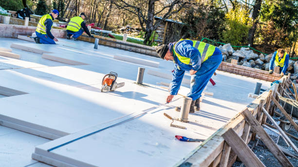 Group of manual workers working on the flooring insulation of a house.
